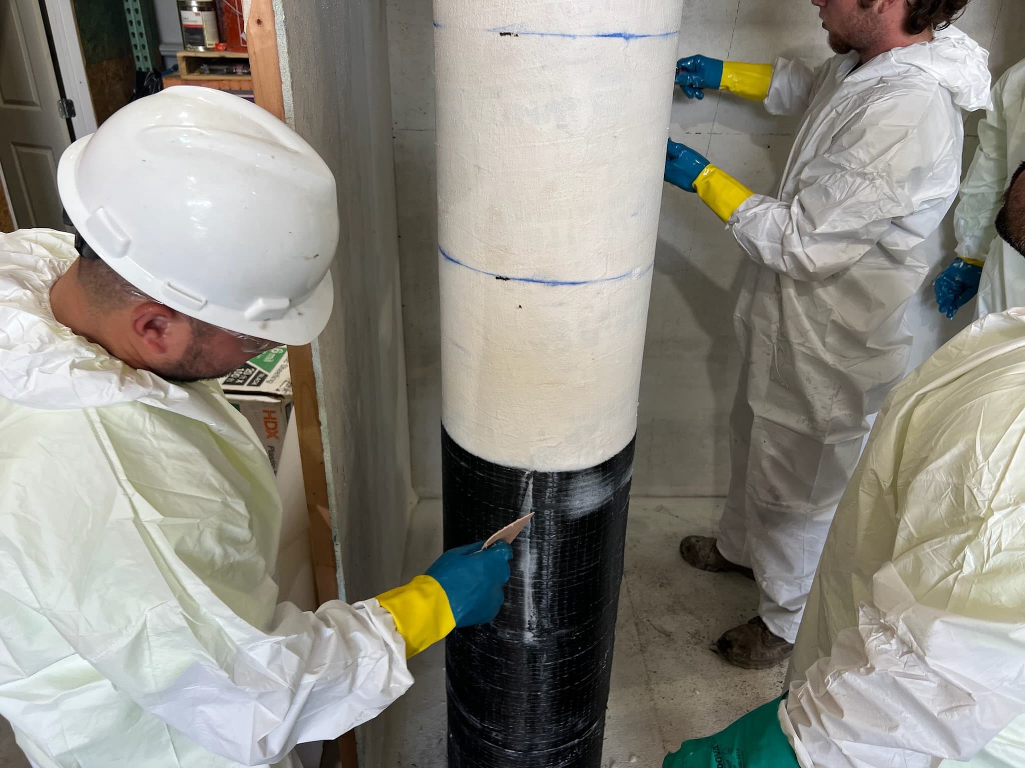 Installer working a lap on carbon fiber wrapped around a round column