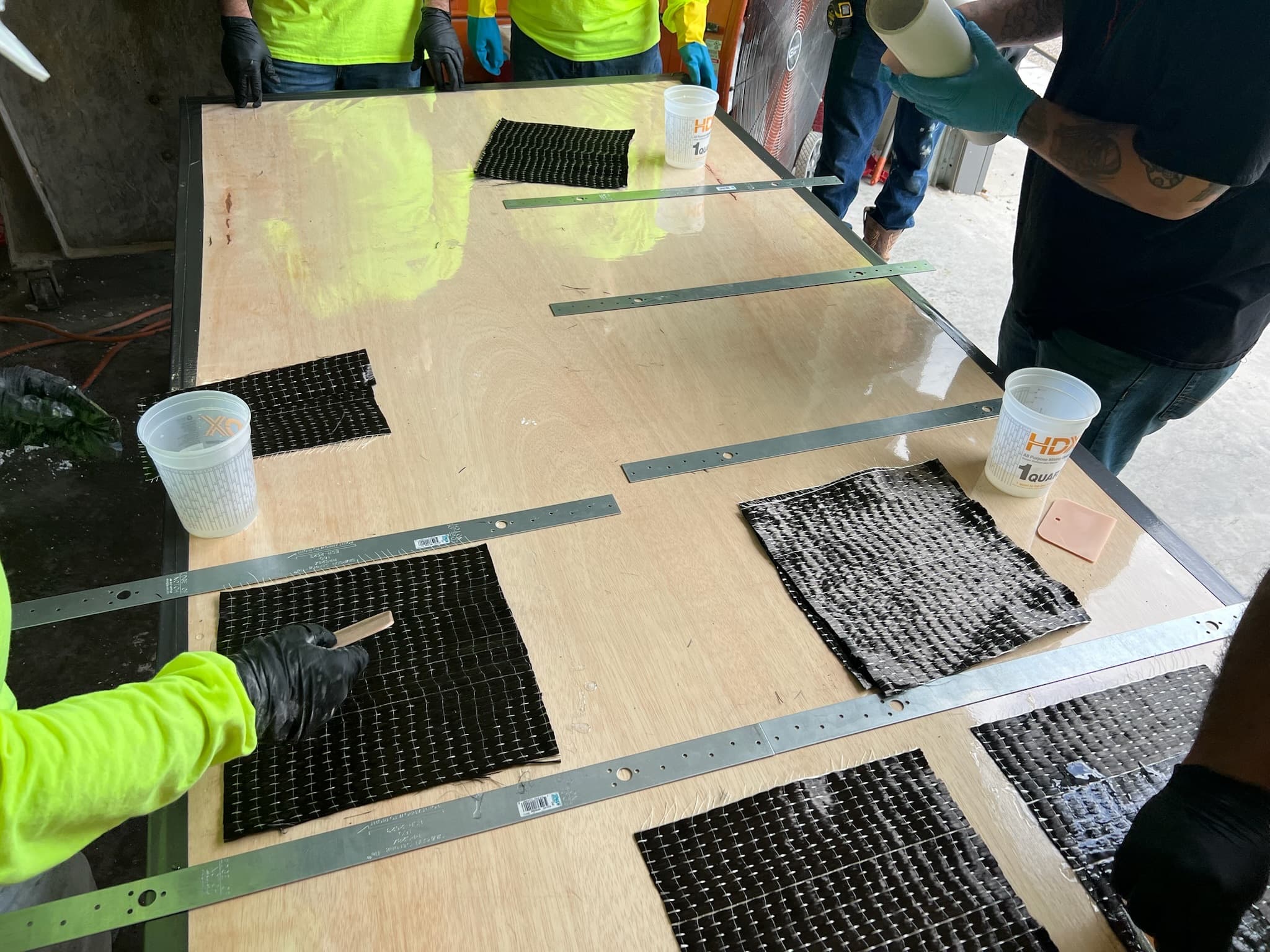 Carbon fiber sample laminates saturated and laid out on a panel table