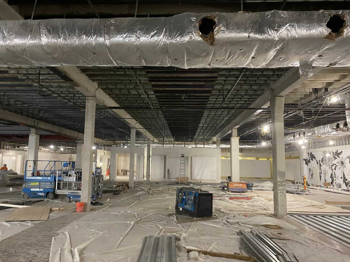 Wide floor under a joist ceiling with carbon fiber strips beyond an insulated duct.
