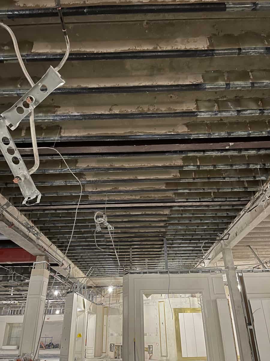 Joist ceiling with carbon fiber bands and hangers above interior walls.
