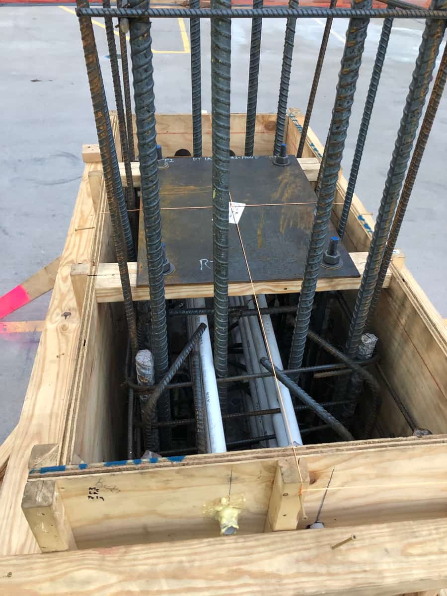 Looking down into a column form with a rebar cage and conduits.