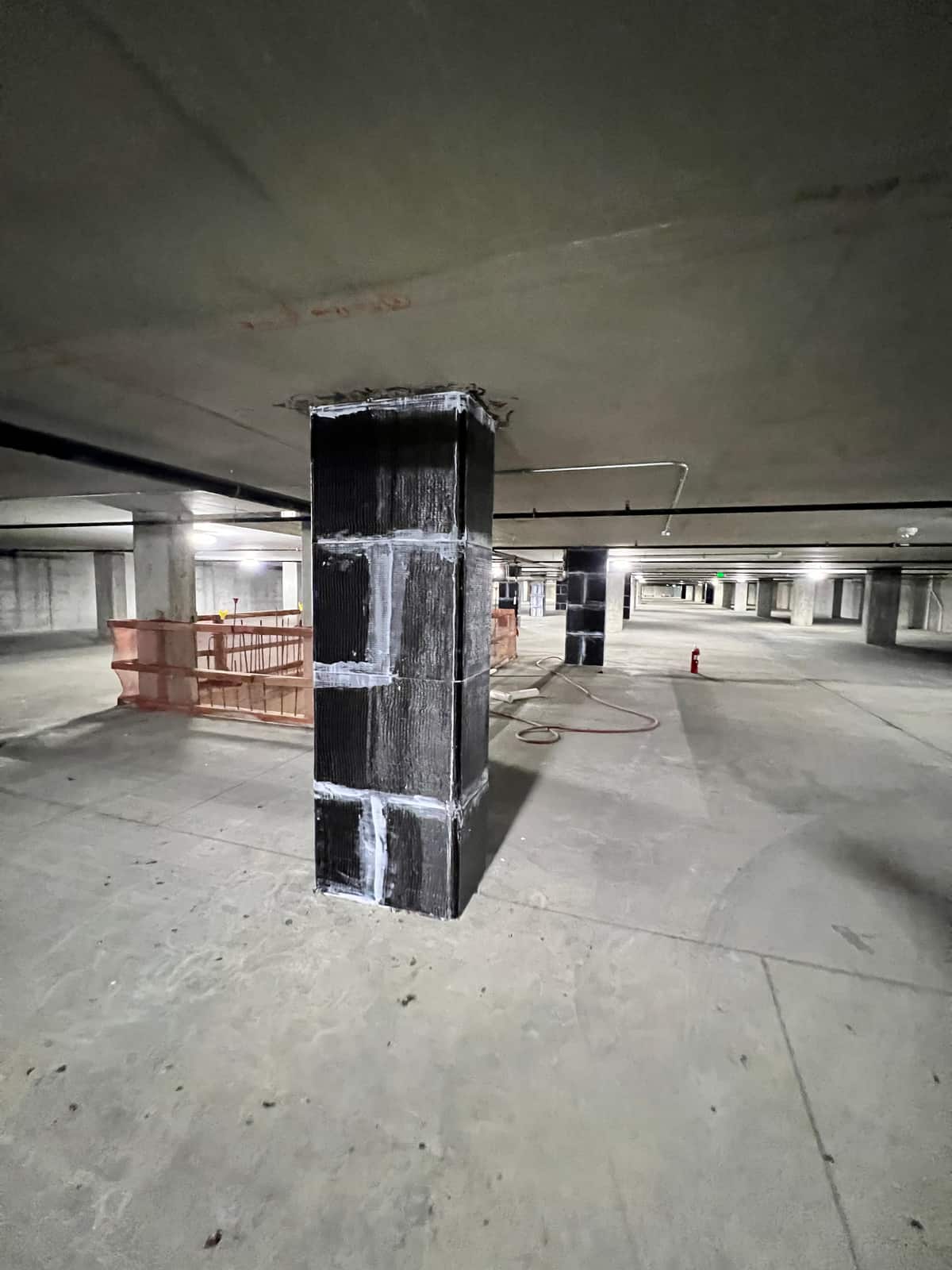 Carbon fiber wrapped column standing in a parking garage.