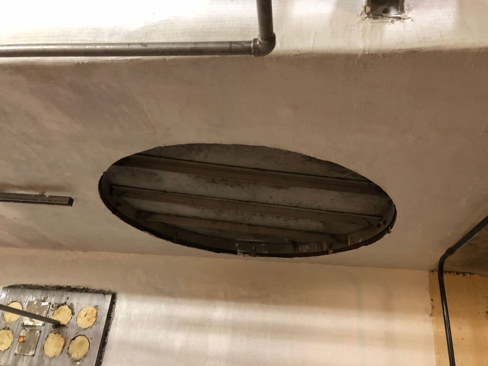 White-coated tank support with a circular outlet opening and a patched plate.
