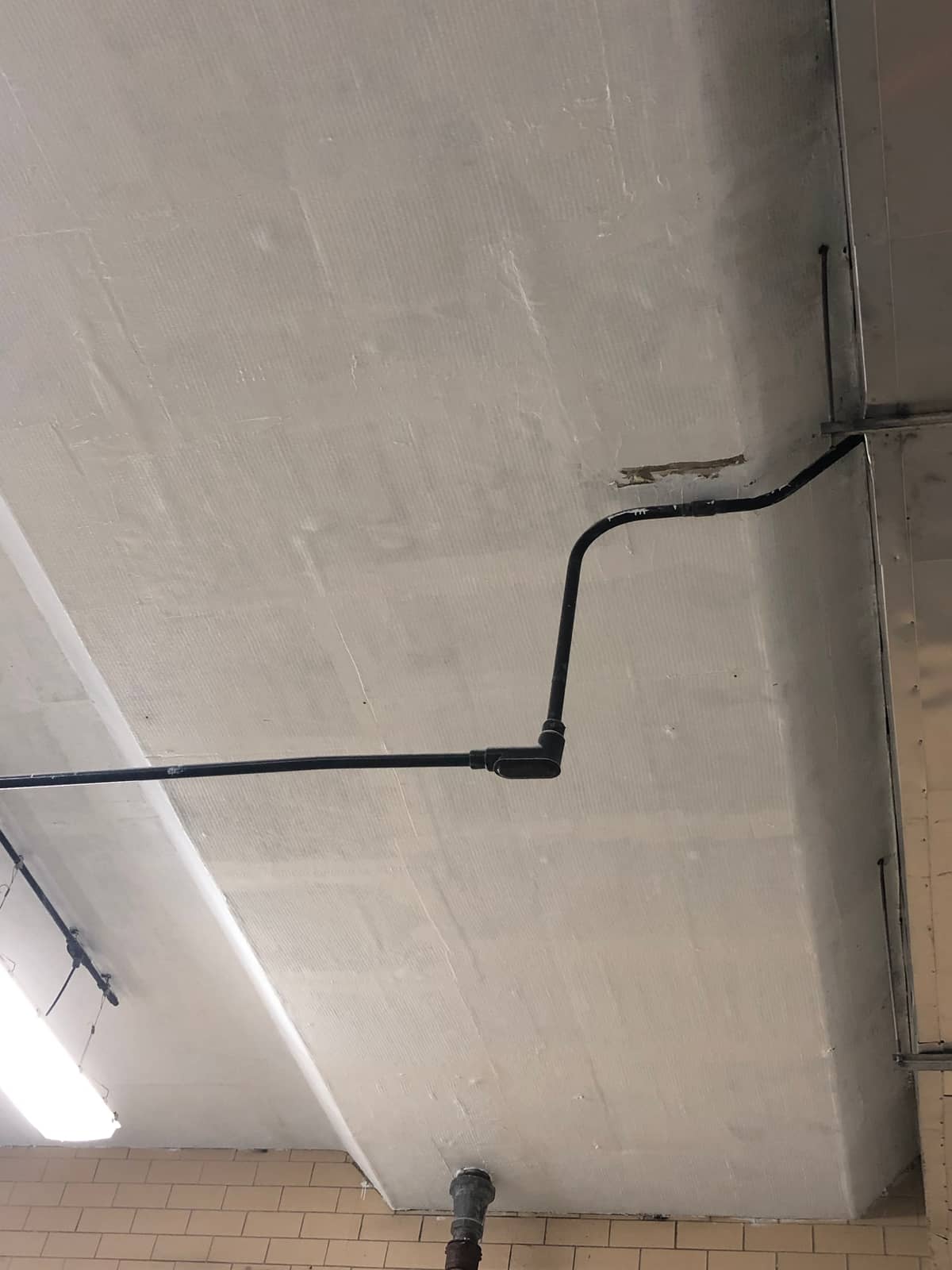 Painted beam soffit showing the fabric weave of a coated composite wrap.