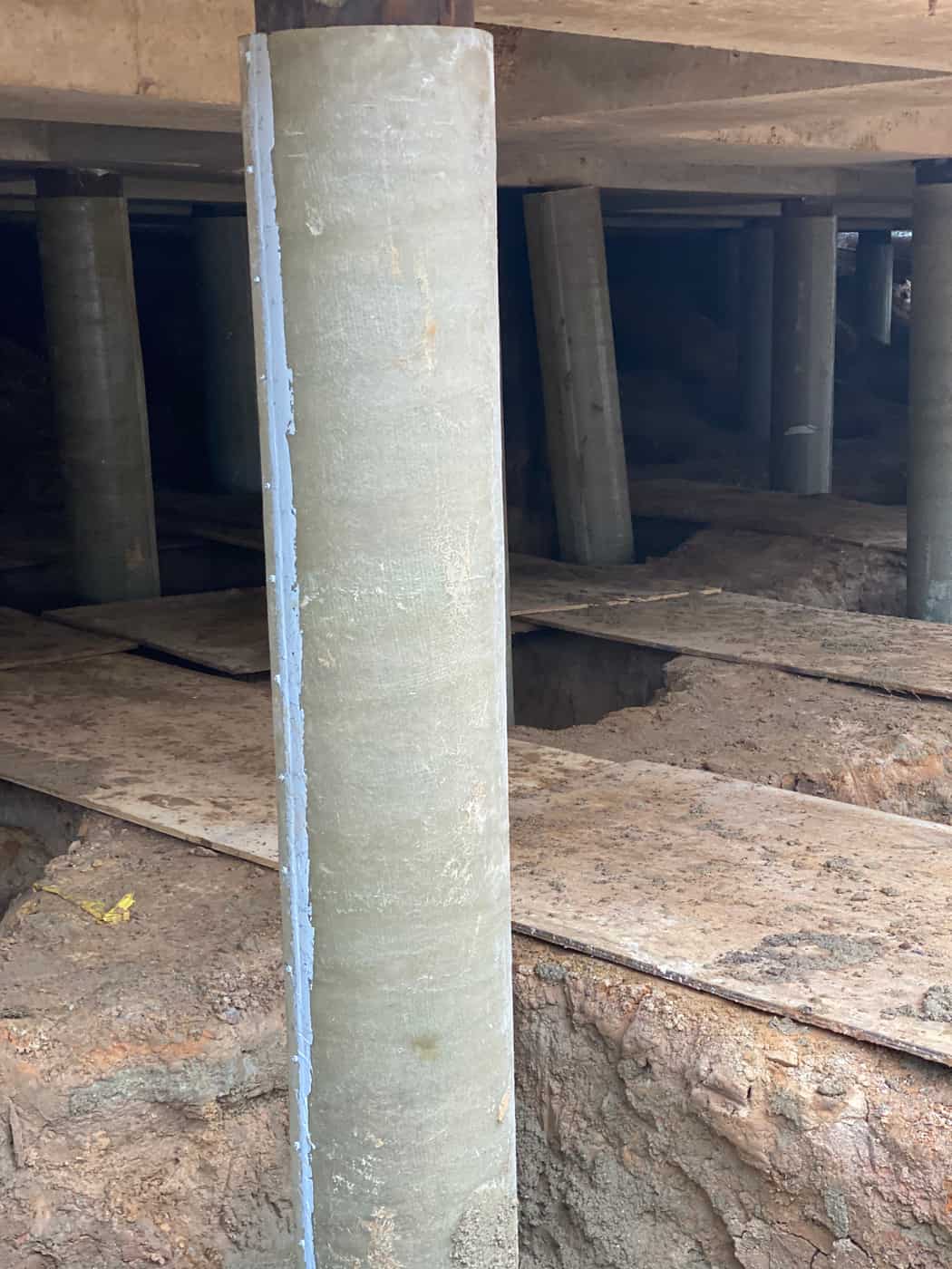 Fiberglass jacket with a sealed vertical seam around a pile beneath a concrete deck.
