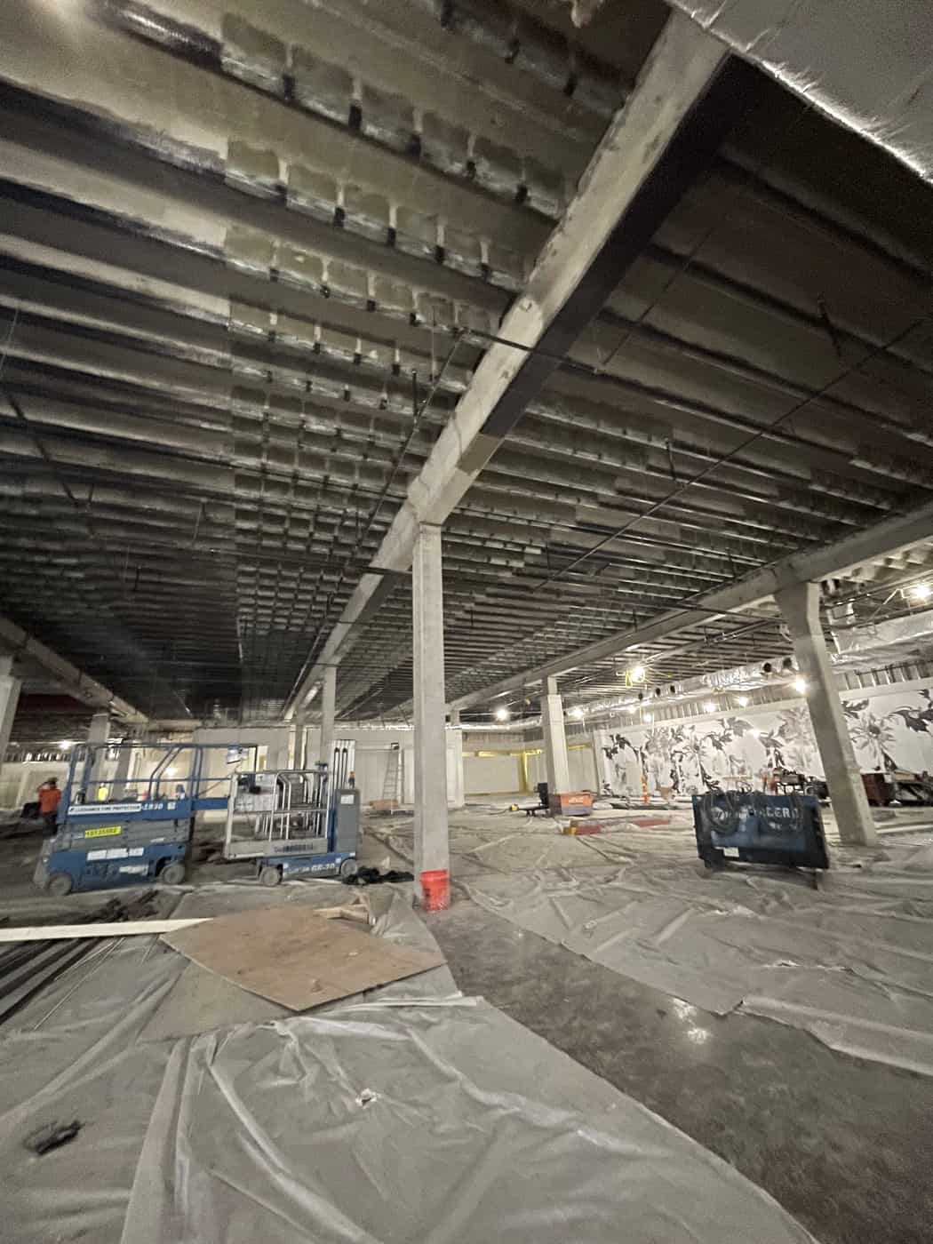 Joist ceiling with carbon fiber strips over an open floor with lifts.