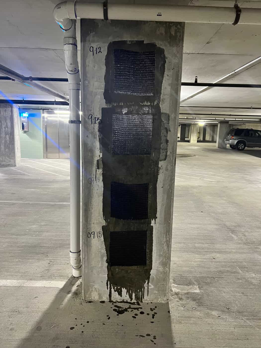 Garage column with the first carbon fiber sheets applied over layout marks.