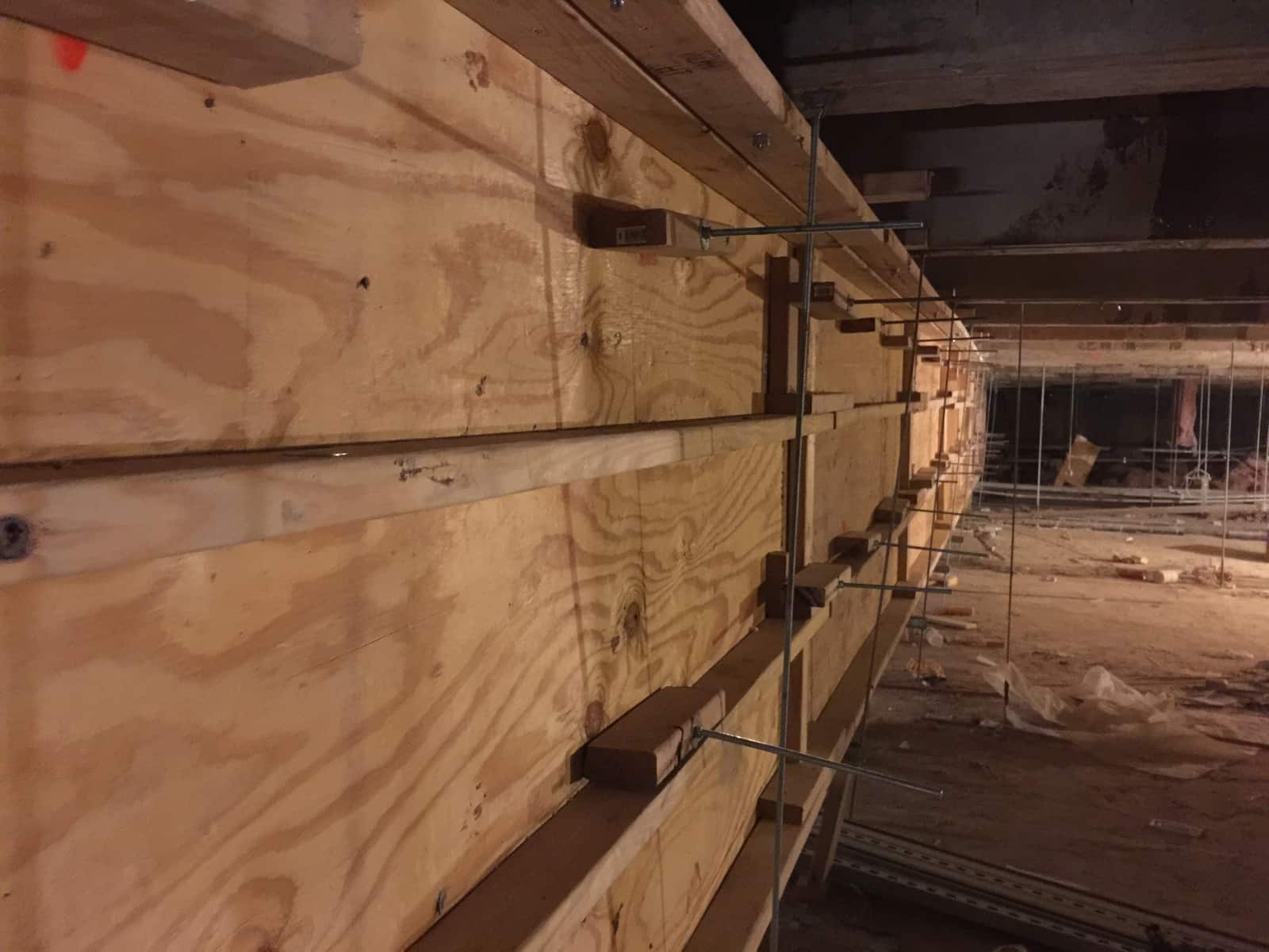 Close view of plywood beam formwork with form ties and bracing.